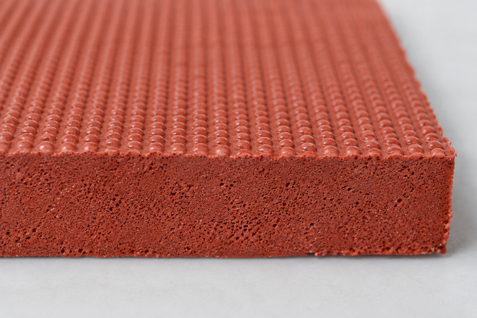Close view of fine pores within the cut edge of a cellular rubber specimen