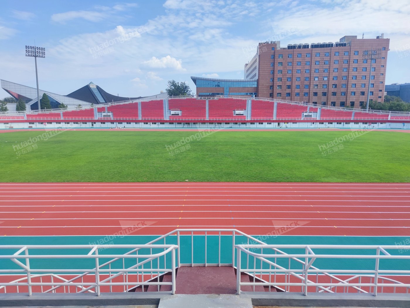Red running track alongside the grass field at Shijingshan Stadium